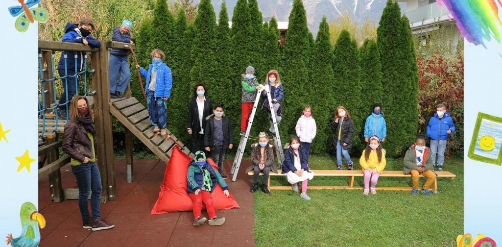 2b-Kinder sitzen im Garten und am Klettergerüst - mit Maske
