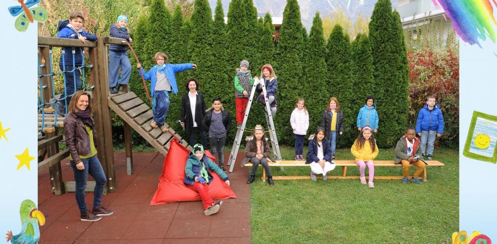 2b-Kinder sitzen im Garten und am Klettergerüst