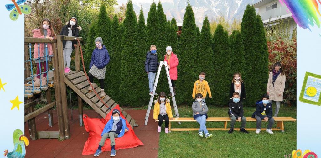 3b-Kinder sitzen im Garten und am Klettergerüst - mit Maske