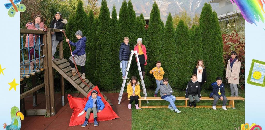 3b-Kinder sitzen im Garten und am Klettergerüst