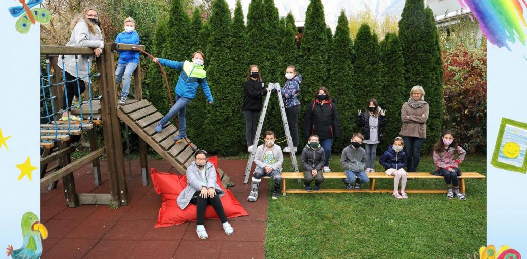 4b-Kinder sitzen im Garten und am Klettergerüst - mit Maske
