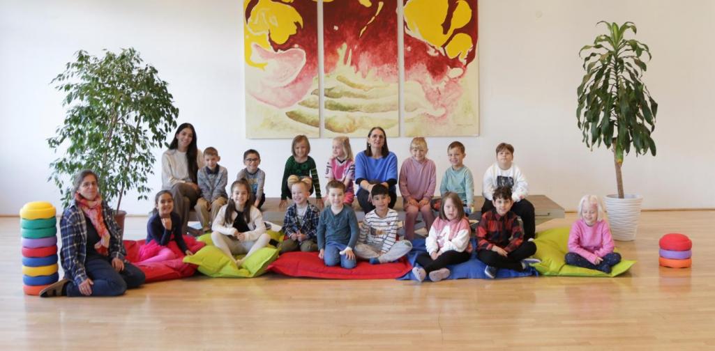 Kinder und Lehrpersonen lachen in die Kamera