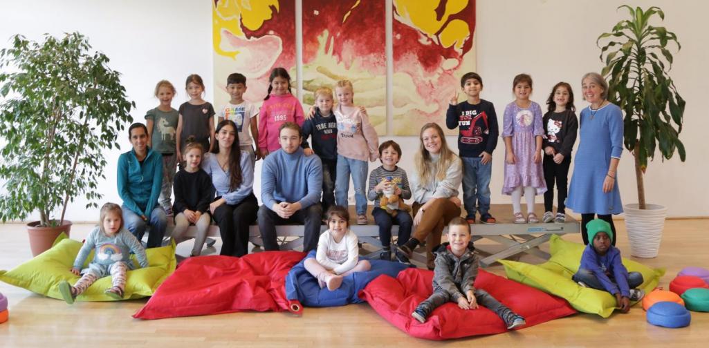 Kinder und Lehrpersonen lachen in die Kamera