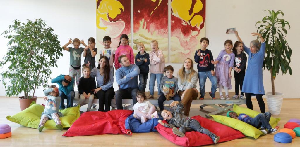 Kinder und Lehrpersonen lachen in die Kamera