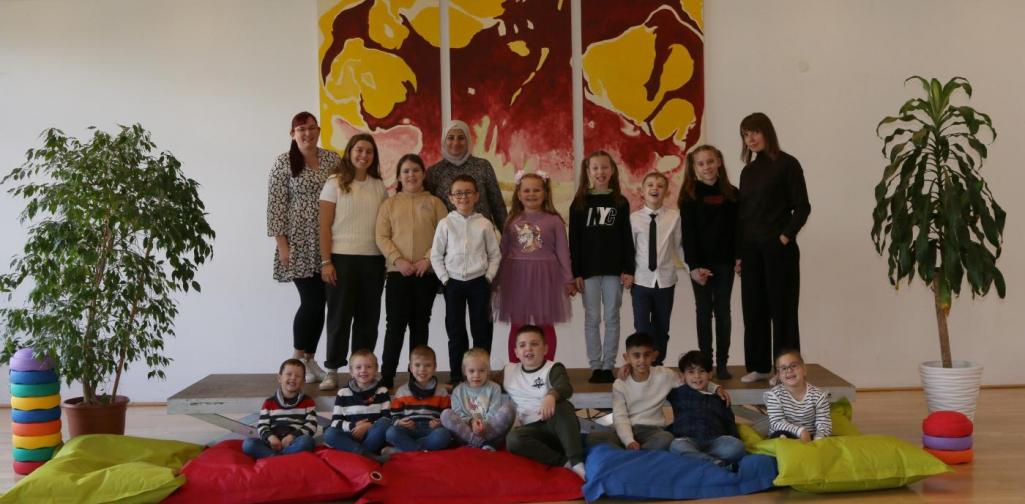 Kinder und Lehrpersonen lachen in die Kamera