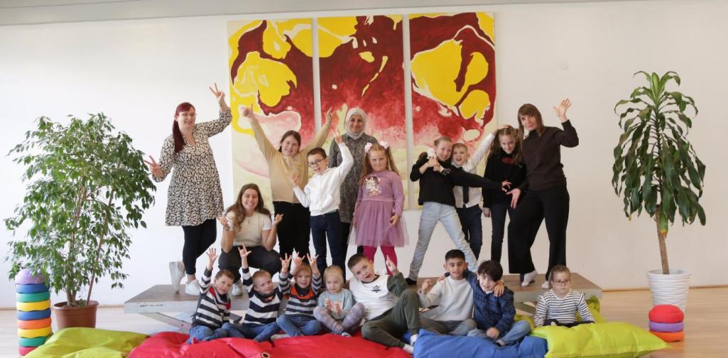 Kinder und Lehrpersonen lachen in die Kamera