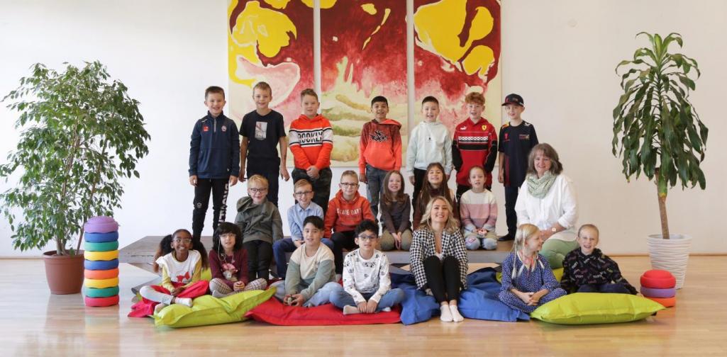 Kinder und Lehrpersonen lachen in die Kamera