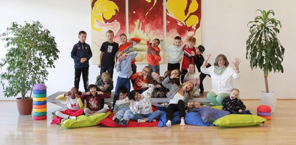 Kinder und Lehrpersonen lachen in die Kamera