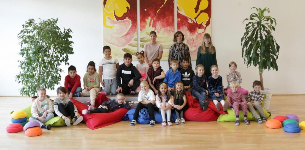 Kinder und Lehrpersonen lachen in die Kamera