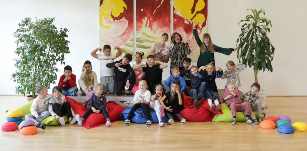 Kinder und Lehrpersonen lachen in die Kamera