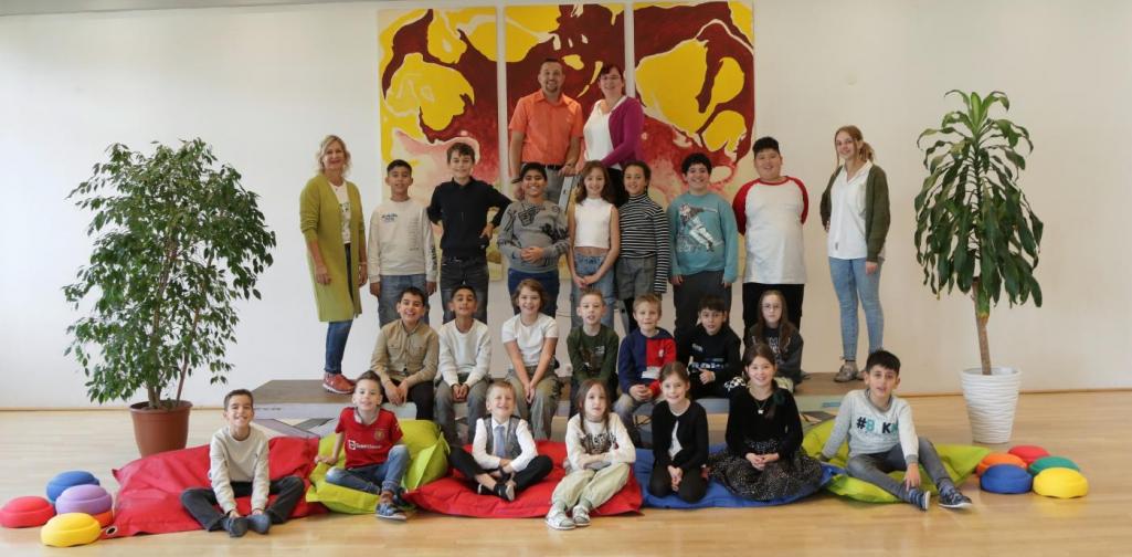 Kinder und Lehrpersonen lachen in die Kamera