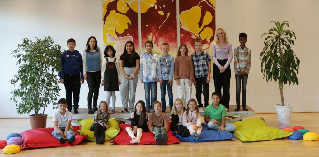 Kinder und Lehrpersonen lachen in die Kamera