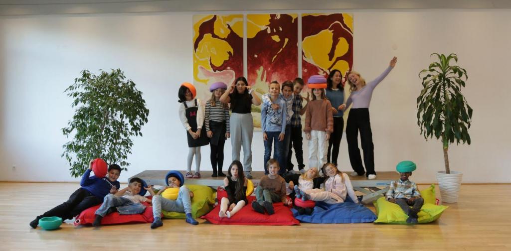 Kinder und Lehrpersonen lachen in die Kamera