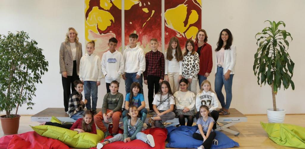 Kinder und Lehrpersonen lachen in die Kamera