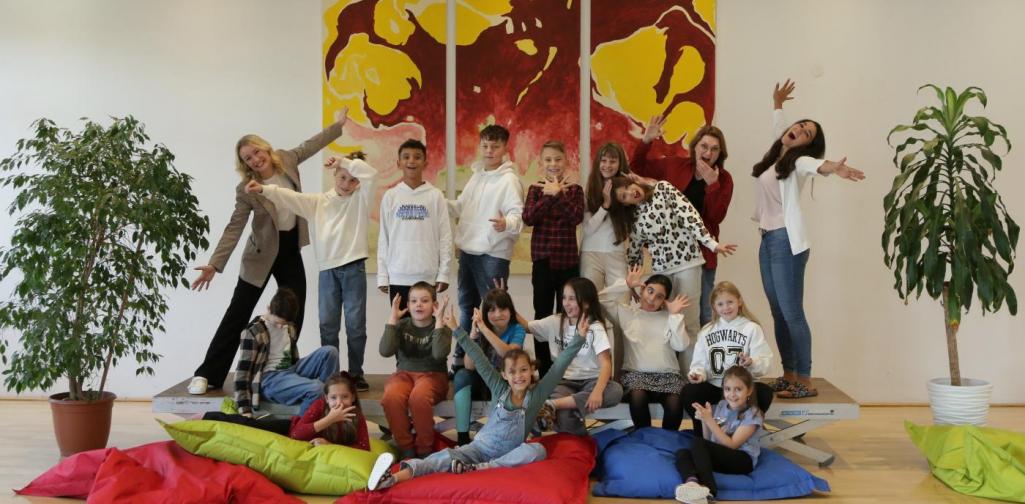 Kinder und Lehrpersonen lachen in die Kamera