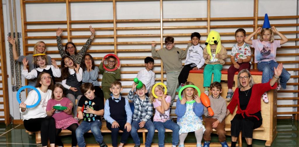 2a macht Unsinn auf Langbänken und Kästen mit buntem Spielmaterial im Turnsaal.