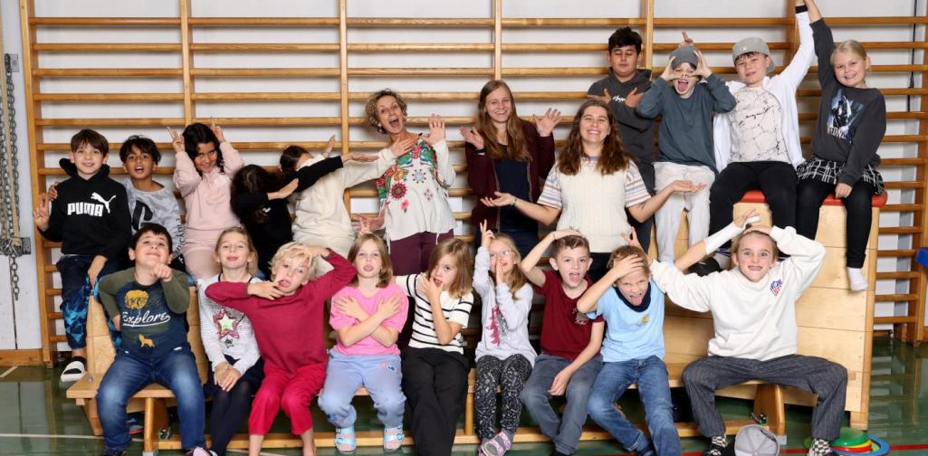 3b macht Unsinn auf Langbänken und Kästen mit buntem Spielmaterial im Turnsaal.