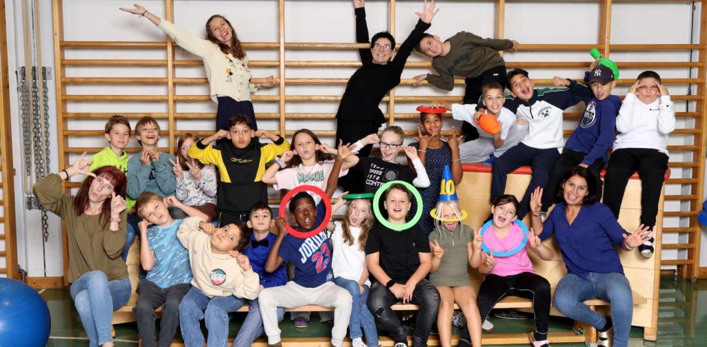 4a macht Unsinn auf Langbänken und Kästen mit buntem Spielmaterial im Turnsaal.