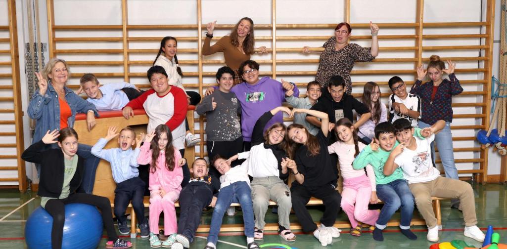 4b macht Unsinn auf Langbänken und Kästen mit buntem Spielmaterial im Turnsaal.