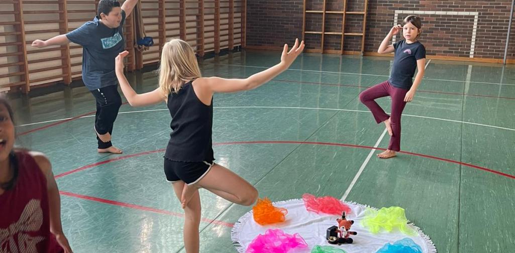 Yoga1 4 Kinder stehen auf einem Bein im Turnsaal