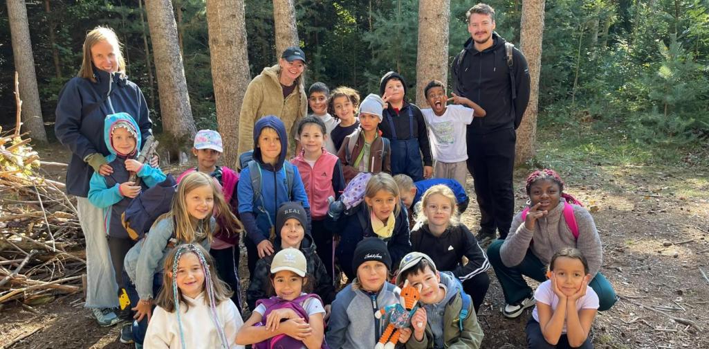 VS Amras Gruppenfoto der Kinder und Lehrpersonen im Wald.